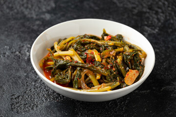 Korean fermented Young Radish leaves Kimchi in white bowl. Healthy food.