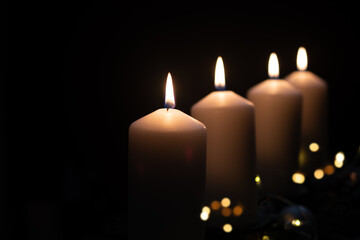 Fourth advent, four candles - candlelight on dark brown panorama background - advent banner. Horizontal banner for homepage. Template for greeting cards, funeral cards and obituaries.