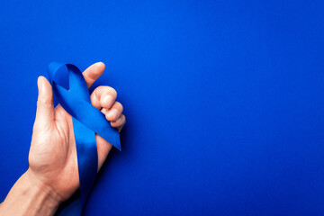 Prostate care. Awareness prostate cancer of men health in November. Blue ribbon in hands isolated...