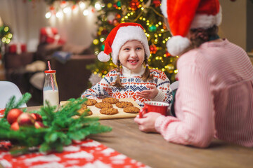 Merry Christmas. My daughter helps my mother cook. Family cooking of festive food. Mother and daughter are making Christmas cookies. happy holidays. Evening time, happy family in the kitchen.