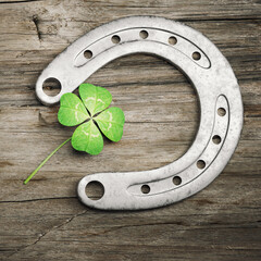 Horseshoe with lucky clover on wooden background. 3d illustration