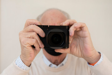 nonno in primo piano che mette a fuoco con la sua nuova macchina fotografica