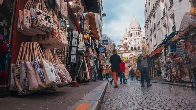Timelapse of Montmartre shopping street near Sacre Coeur cathedral with tourists and Parisians walking around