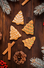 Various cookies are on the wooden table with pine tree branches. - 474554860