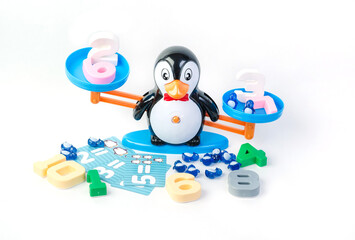 Childrens toy for development - scales in the form of a penguin with multi-colored numbers on a white background.