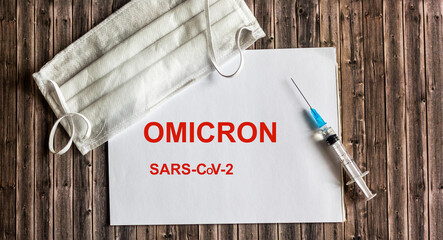 word omicron on notepad with mask and corona virus vaccine. Omicron is a new type of corona virus...