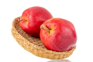 Two juicy red apples with a straw plate, close-up, isolated on white.