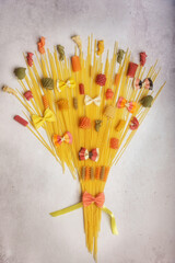 A different decorative bouquet of different types of spaghetti on colorful backgrounds. Food Concept