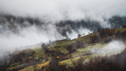 Mountain landscape with clouds climbing through the hills