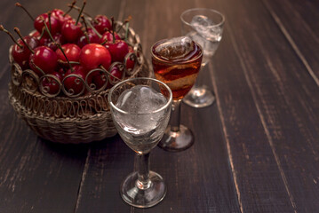 Alcoholic drinks in glass piles on a wooden table. Cherry, nut and lemon liqueurs.