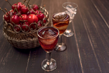 Alcoholic drinks in glass piles on a wooden table. Cherry, nut and lemon liqueurs.