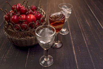 Alcoholic drinks in glass piles on a wooden table. Cherry, nut and lemon liqueurs.
