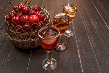 Alcoholic drinks in glass piles on a wooden table. Cherry, nut and lemon liqueurs.