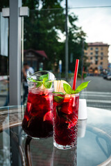 red sangria in a jug and a glass on the cafe table