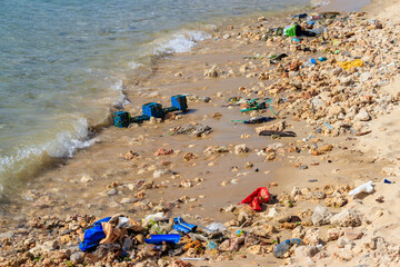 Garbage on a bank of ocean. Pollution of sea, ocean water with waste, plastics garbage. Concept of pollution of ocean, sea and river coastline with plastic trash