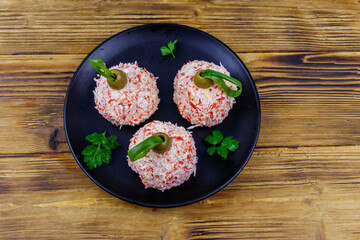 Appetizer of crab-cheese balls made in a shape of Christmas baubles on wooden table. Top view