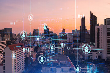 Hologram of social media icons over sunset panoramic cityscape of Bangkok, Southeast Asia. The concept of people connections and career opportunities. Multi exposure.