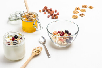 Berries and cereals in bowl. Yogurt in jar.