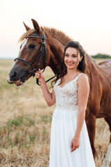 Obraz premium bride in a white dress next to a brown horse