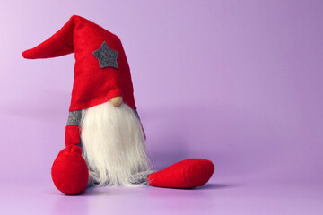 A dwarf with a white beard in the form of Santa Claus on a purple background very peri