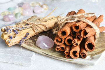 Obraz na płótnie Canvas A close up image of healing smudge sticks and rose quartz crystals on a hand made pottery plate. 