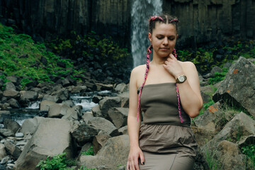 beautiful girl in a dress next to Svartifoss waterfall in the Skaftafell National Park, iceland