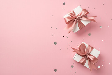 Top view photo of white gift boxes with pink silk ribbon bows silver sequins and heart shaped...