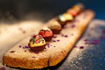 small sweet colored muffins on a wooden board