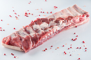 raw pork ribs with spices on a white background