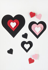 Black white red and pink hearts cut out of paper