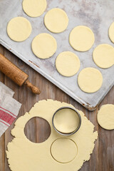 Rolled out shortbread dough. Cutting out cookies.   Shortcrust pastry.  Round unbaked biscuits....
