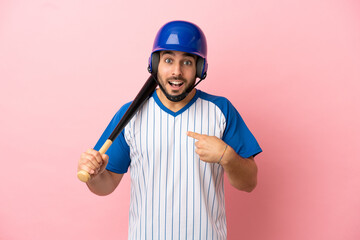 Baseball player with helmet and bat isolated on pink background with surprise facial expression