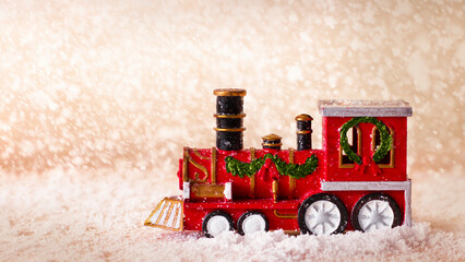  Christmas red train on a blurred snowy background.