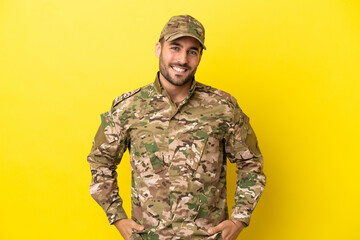 Military man isolated on yellow background laughing