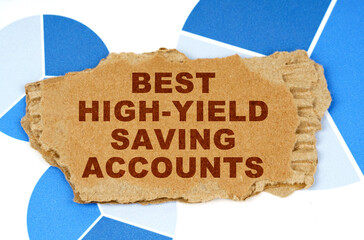 On the blue financial charts is a piece of cardboard that says - Best High-Yield Saving Accounts