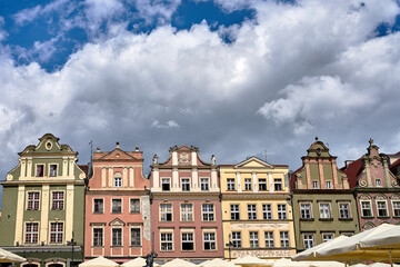 Fototapeta na wymiar facades of historic tenements houses and umbrellas of the restauranton the Old Market Square in Poznan 