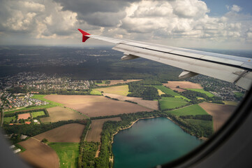 Ein Blick aus einem Fenster eines Flugzeugs mit Blick über einem See und Felder mit schönen...