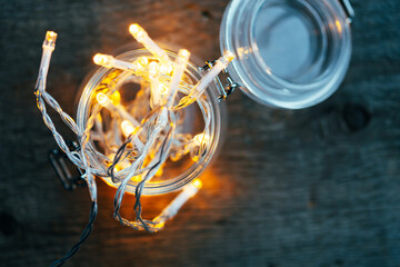 top view of Fairy lights in a glass jar on dark wooden table