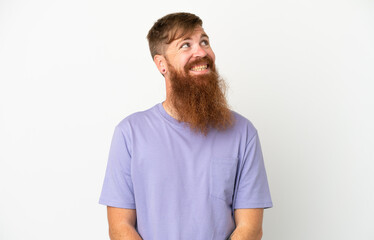 Obraz premium Young reddish caucasian man isolated on white background thinking an idea while looking up