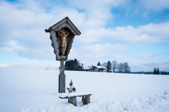 Flurkreuz / Jesuskreuz / Wegekreuz in verschneiter Winterlandschaft in Bayern