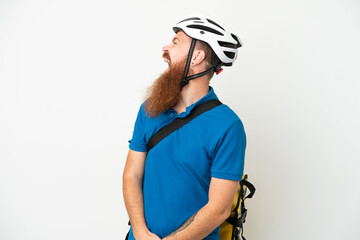 Young reddish caucasian man with thermal backpack isolate don white background laughing in lateral position