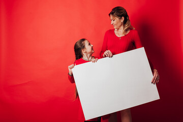 a girl and a mother holding a sign for an inscription on a red background