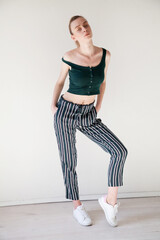 portrait of a beautiful fashionable woman in green clothes on a white background