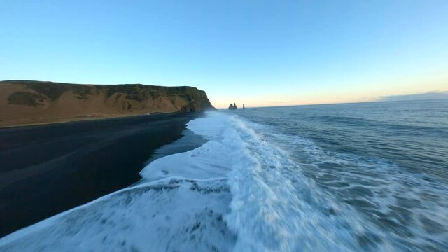 Aerial fpv view of black beach Vik during sunset, Iceland. 