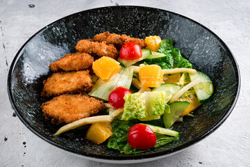 Colorful vegetable dish with mixed orange, nuggets, lettuce and tomatoes. Beautiful view of restaurant healthy food