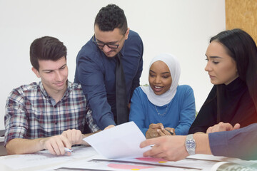 Talented group of international students cooperating together with professor on technical planning...