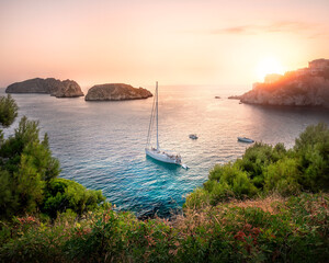 mediterranean coast during sunset with island and boat