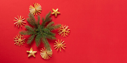 Fluffy branches of fir-tree Christmas toys made from natural materials of straw, red background. concept Christmas New Year.