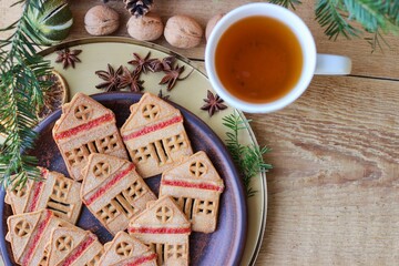 Christmas eve. Cookies in shape of houses and cup of tea