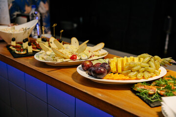 Meal. Festive buffet table for guests. Assortment of cold cuts,canapes on wooden skewers, festive snacks with fruits and salads. Reception at the party.